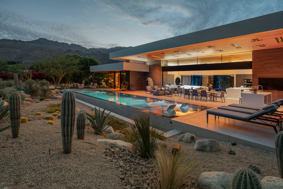 На фото: огромный прямоугольный бассейн на заднем дворе в стиле модернизм