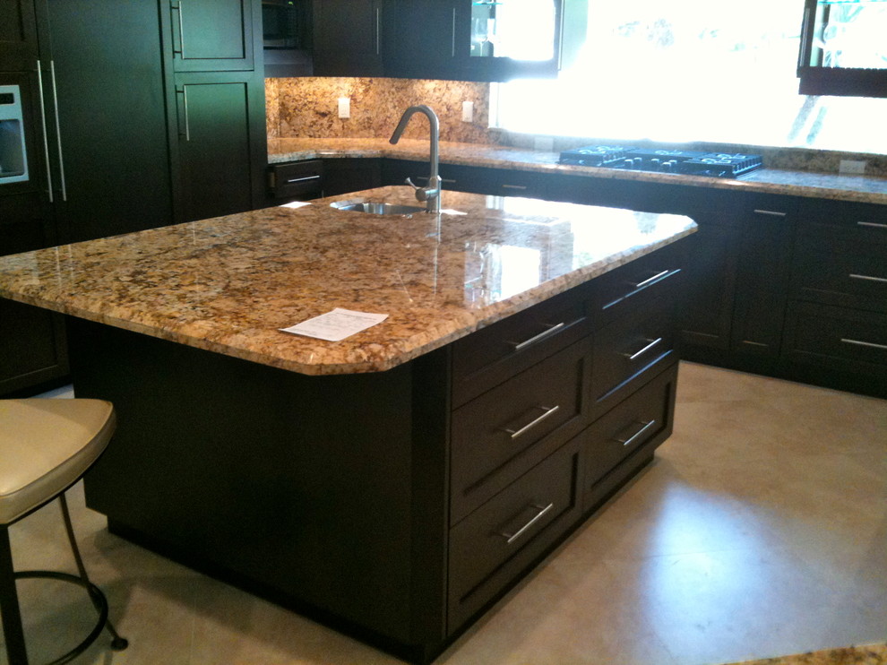 Large transitional u-shaped travertine floor and beige floor open concept kitchen photo in Miami with an undermount sink, shaker cabinets, dark wood cabinets, granite countertops, multicolored backsplash, stone tile backsplash, stainless steel appliances and an island
