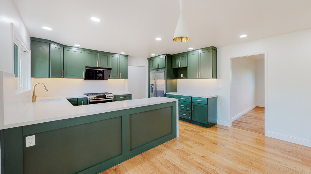 Design ideas for a mid-sized eclectic l-shaped eat-in kitchen in San Francisco with an undermount sink, shaker cabinets, green cabinets, limestone benchtops, white splashback, limestone splashback, stainless steel appliances, bamboo floors, with island, beige floor and white benchtop.