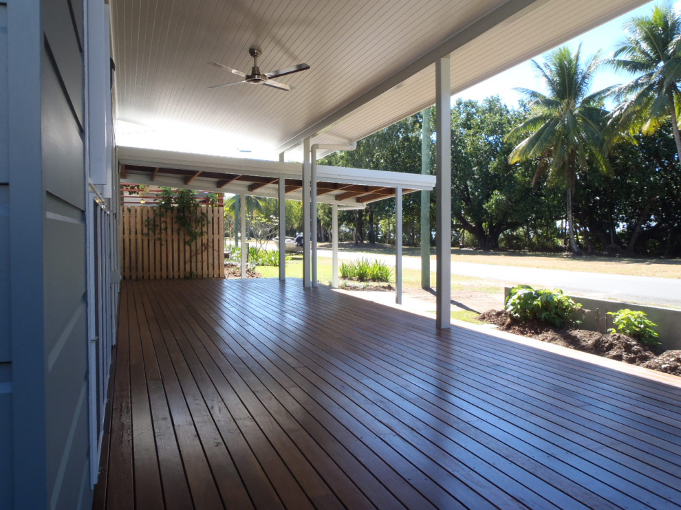 Design ideas for a beach style one-storey grey house exterior in Cairns with wood siding, a flat roof and a metal roof.
