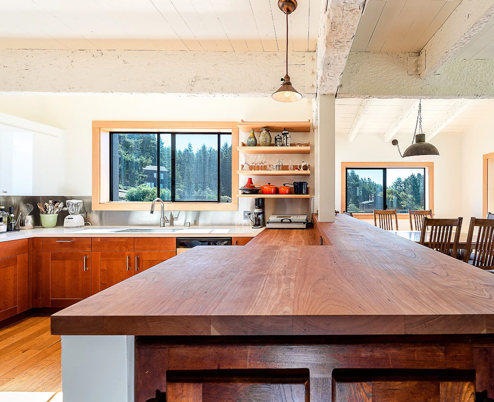 Inspiration for a mid-sized country u-shaped eat-in kitchen in San Francisco with a single-bowl sink, shaker cabinets, medium wood cabinets, wood benchtops, metallic splashback, metal splashback, stainless steel appliances, medium hardwood floors and a peninsula.