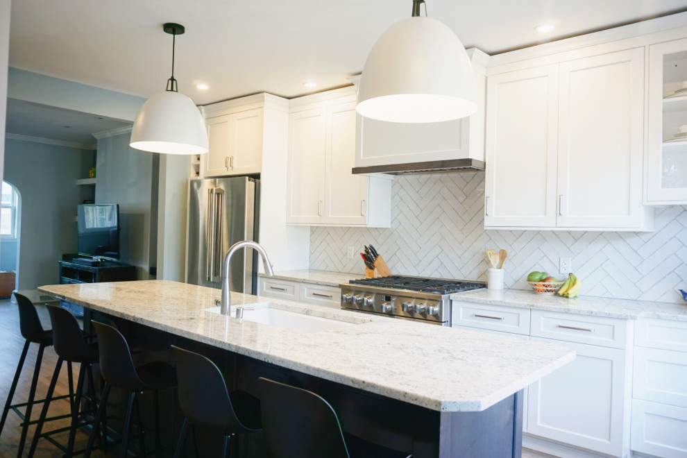 Eat-in kitchen - huge transitional light wood floor and brown floor eat-in kitchen idea with an undermount sink, shaker cabinets, white cabinets, granite countertops, white backsplash, ceramic backsplash, stainless steel appliances, an island and white countertops