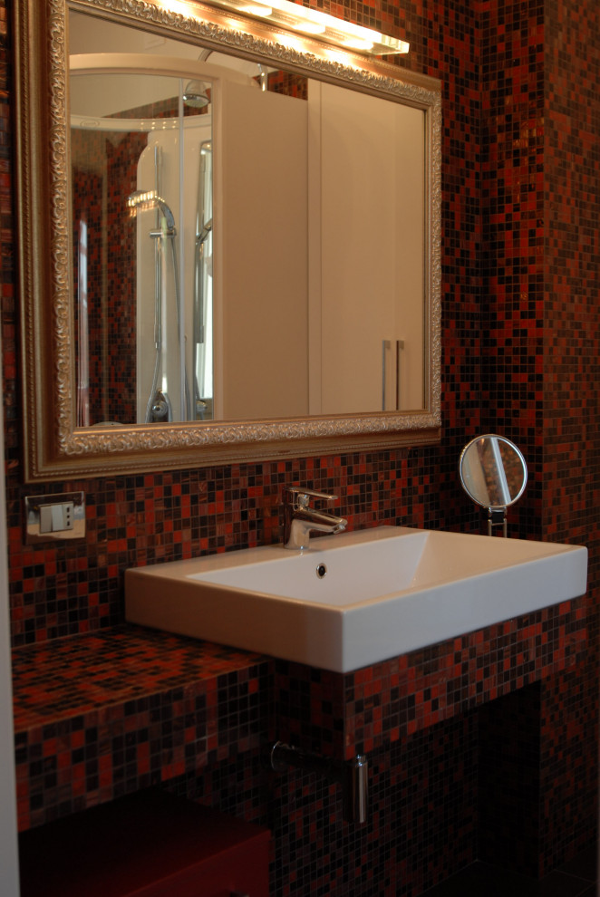 Design ideas for a contemporary cloakroom in Bologna with open cabinets, red cabinets, a wall mounted toilet, red tiles, light hardwood flooring, a built-in sink, glass worktops, red worktops and a built in vanity unit.