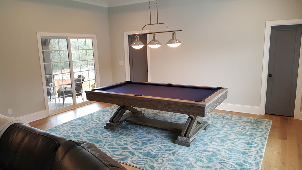 Inspiration for a large contemporary open concept family room in Charlotte with a game room, grey walls and light hardwood floors.