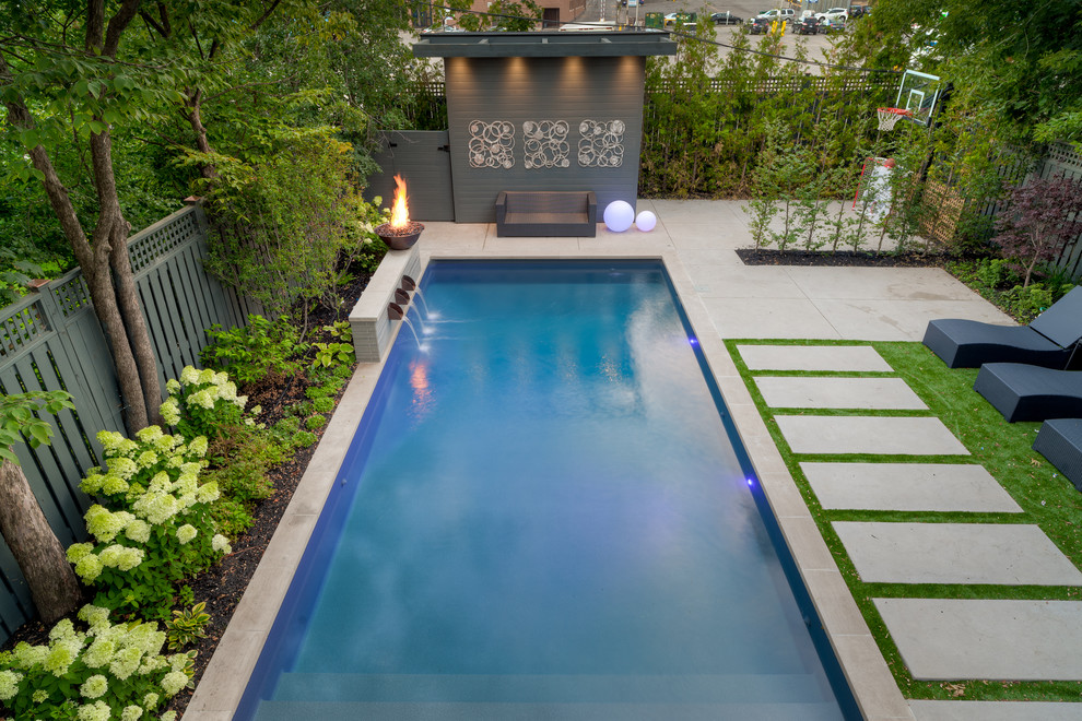Inspiration for a mid-sized contemporary backyard rectangular lap pool in Toronto with a water feature and concrete pavers.