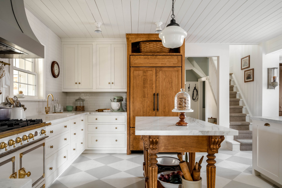 トロントにある高級な中くらいなシャビーシック調のおしゃれなキッチン (落し込みパネル扉のキャビネット、白いキャビネット、大理石カウンター、白いキッチンパネル、サブウェイタイルのキッチンパネル、パネルと同色の調理設備、グレーの床、白いキッチンカウンター、塗装板張りの天井、ドロップインシンク) の写真