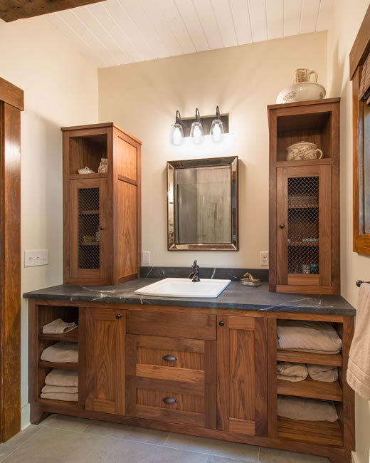 Design ideas for a mid-sized country master bathroom in Other with recessed-panel cabinets, dark wood cabinets, a corner shower, gray tile, white walls, concrete floors, a drop-in sink, soapstone benchtops, cement tile, grey floor and a hinged shower door.
