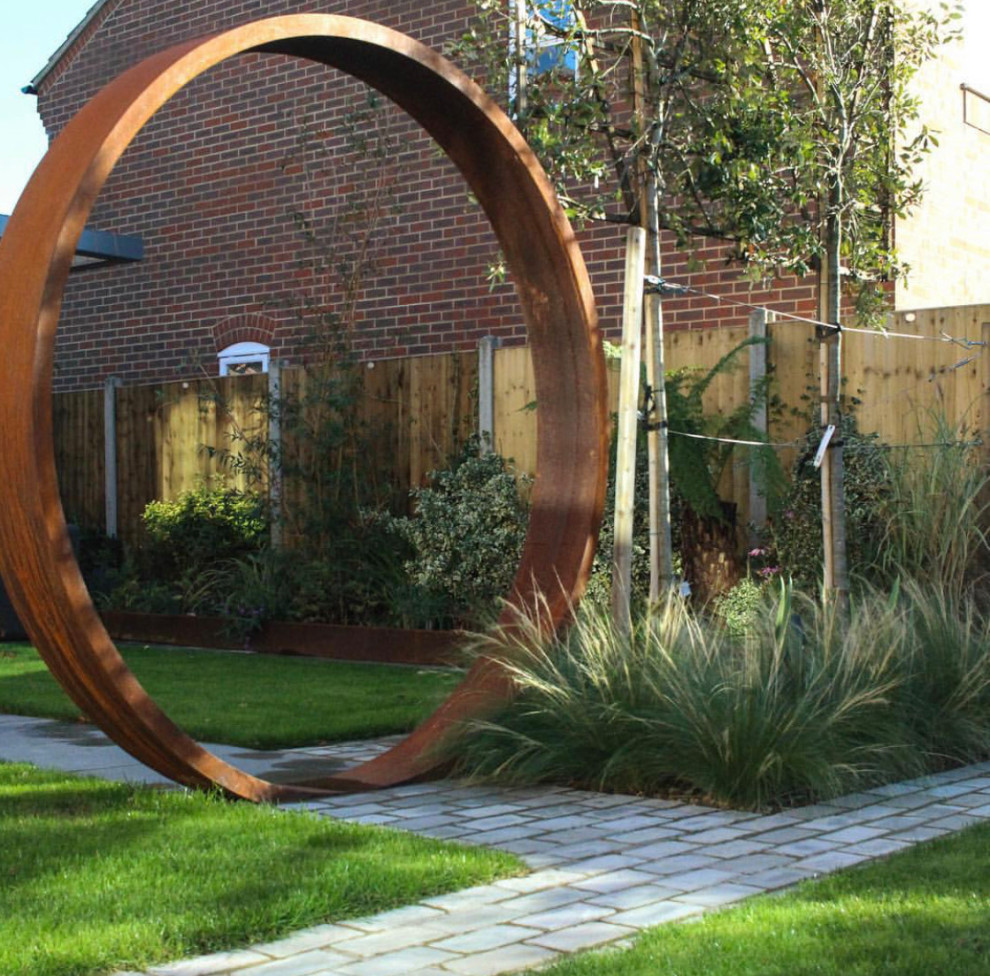 Idee per un giardino minimalista esposto a mezz'ombra di medie dimensioni e dietro casa con un ingresso o sentiero, sassi di fiume e recinzione in metallo