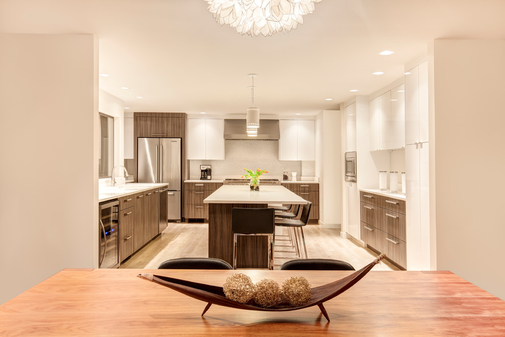 Inspiration for an expansive modern u-shaped eat-in kitchen in Seattle with an undermount sink, flat-panel cabinets, dark wood cabinets, quartz benchtops, grey splashback, stainless steel appliances, light hardwood floors and with island.