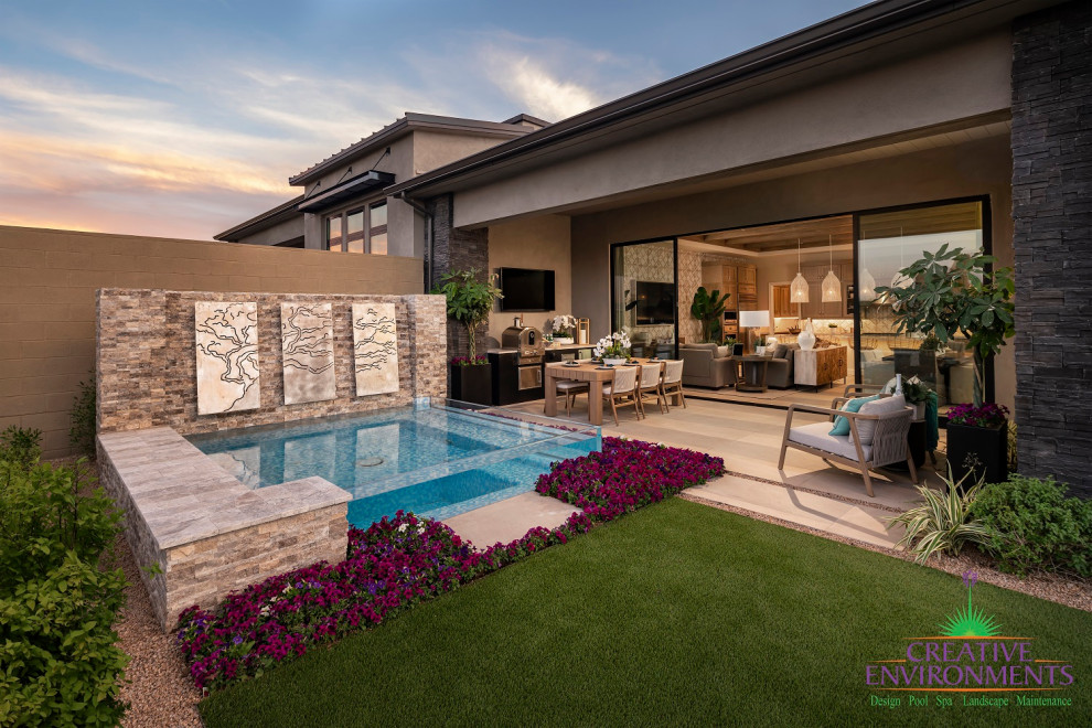 Photo of a large modern drought-tolerant and partial sun backyard concrete paver and metal fence landscaping in Phoenix with a fire pit for summer.