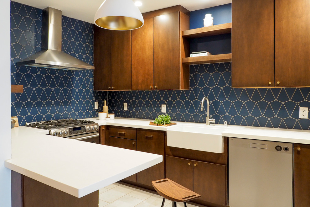 Design ideas for a mid-sized midcentury u-shaped separate kitchen in San Francisco with a farmhouse sink, flat-panel cabinets, dark wood cabinets, blue splashback, stainless steel appliances, ceramic floors, no island, beige floor and white benchtop.