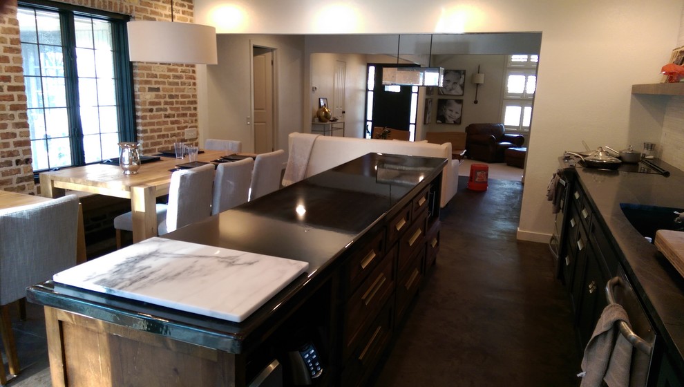 Mid-sized transitional galley open plan kitchen in Dallas with with island, shaker cabinets, black cabinets, soapstone benchtops, an undermount sink, white splashback, matchstick tile splashback, stainless steel appliances and concrete floors.
