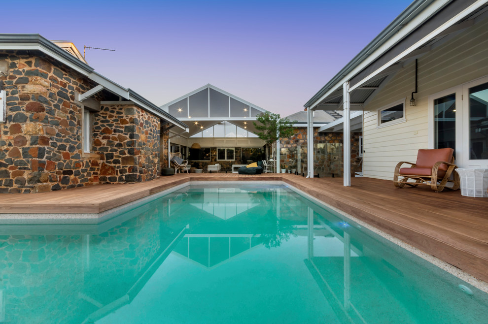 Inspiration for a large beach style backyard l-shaped natural pool in Perth with decking.