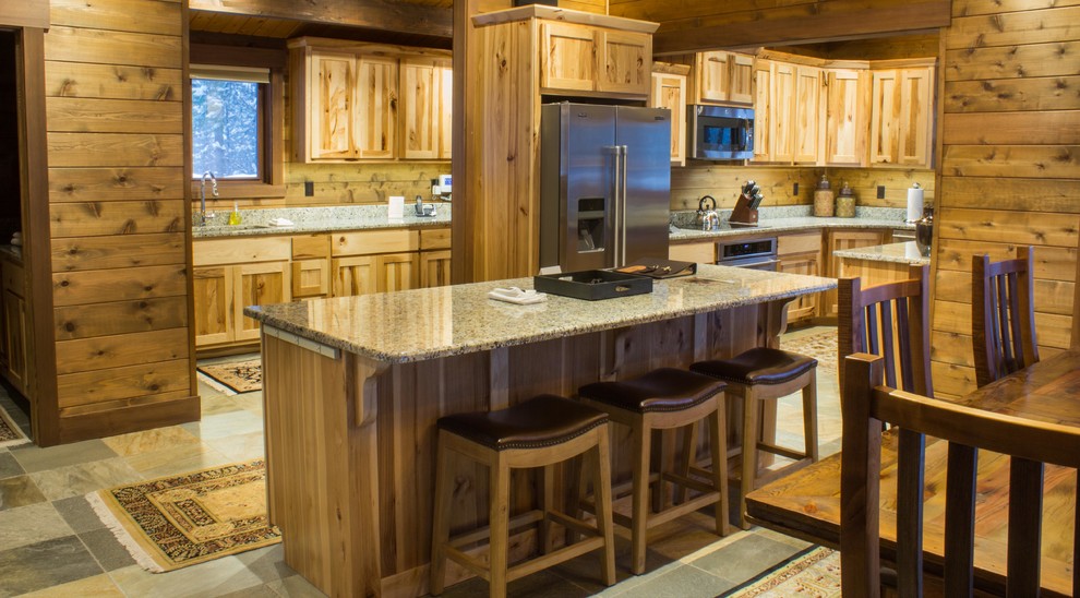 Photo of a mid-sized country l-shaped eat-in kitchen in Other with medium wood cabinets, granite benchtops, stainless steel appliances, slate floors, with island, an undermount sink, shaker cabinets and grey floor.