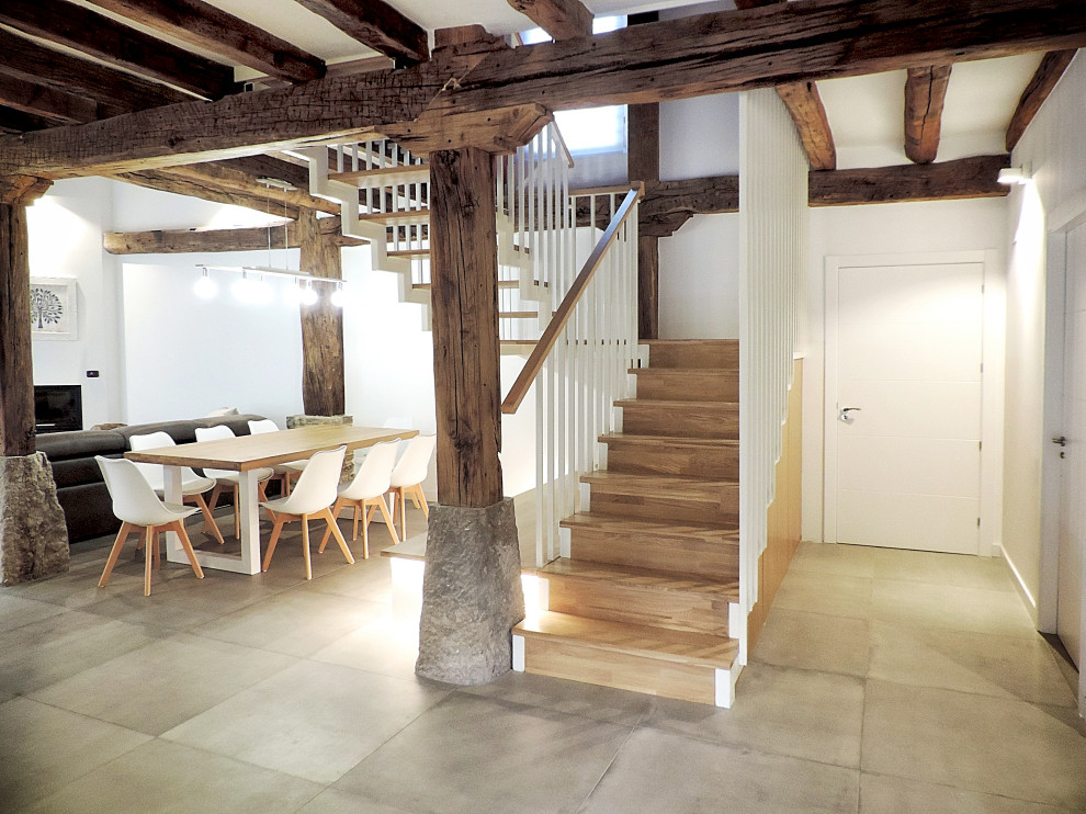 Foto de escalera en L rústica grande con escalones de madera, contrahuellas de madera y barandilla de metal