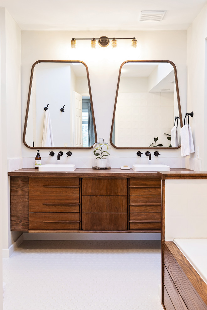 Inspiration for a large midcentury master bathroom with medium wood cabinets, a drop-in tub, wood benchtops, flat-panel cabinets, white walls, a vessel sink, white floor and brown benchtops.