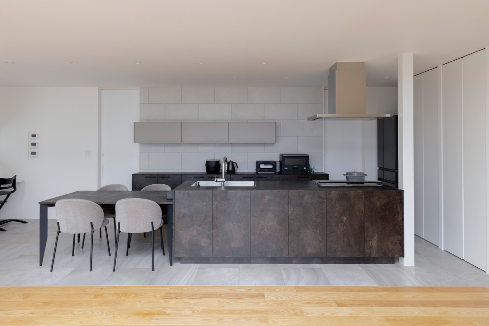 Mid-sized modern single-wall open plan kitchen in Other with an integrated sink, beaded inset cabinets, grey cabinets, quartz benchtops, white splashback, ceramic splashback, stainless steel appliances, light hardwood floors, with island, beige floor, grey benchtop and wallpaper.