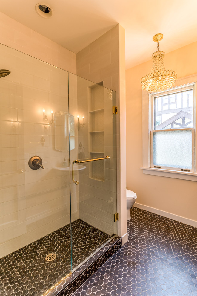 Inspiration for a mid-sized transitional 3/4 porcelain tile and black floor alcove shower remodel in Minneapolis with a one-piece toilet, beige walls, a pedestal sink and a hinged shower door