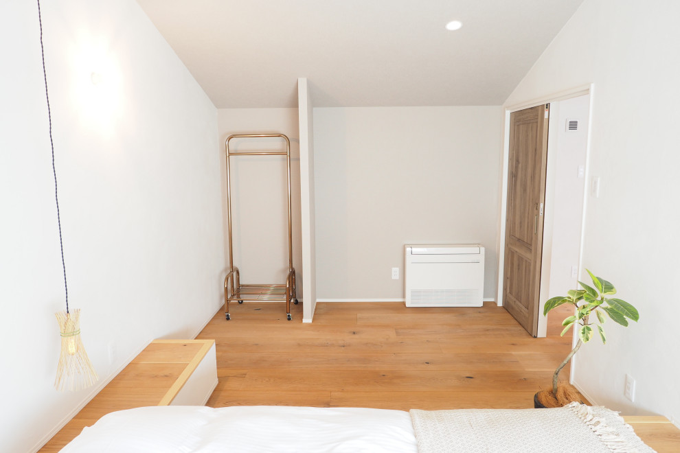 他の地域にあるビーチスタイルのおしゃれな寝室 (白い壁、無垢フローリング、ベージュの床、クロスの天井) のインテリア