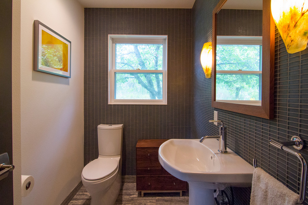 Small contemporary bathroom in Milwaukee with a pedestal sink, flat-panel cabinets, medium wood cabinets, a one-piece toilet, gray tile, glass tile, white walls and porcelain floors.