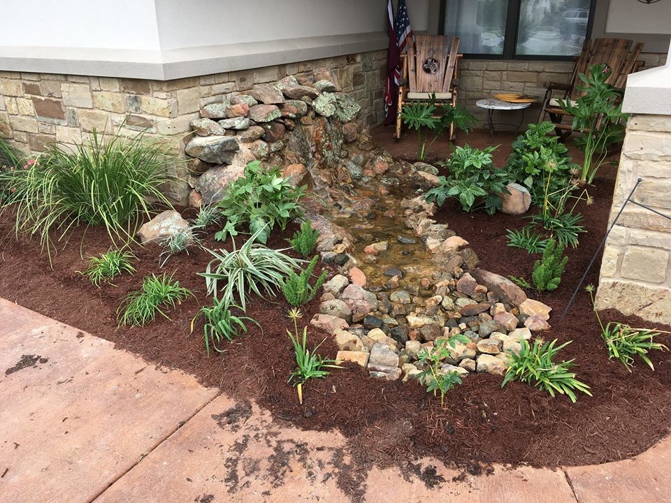Design ideas for a mid-sized rustic full sun front yard mulch landscaping in Austin.