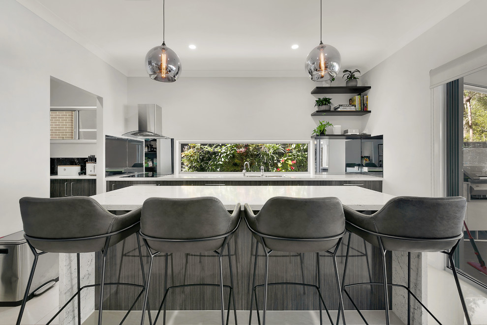 Contemporary kitchen in Brisbane with quartz benchtops, stainless steel appliances, porcelain floors, with island, beige floor and white benchtop.