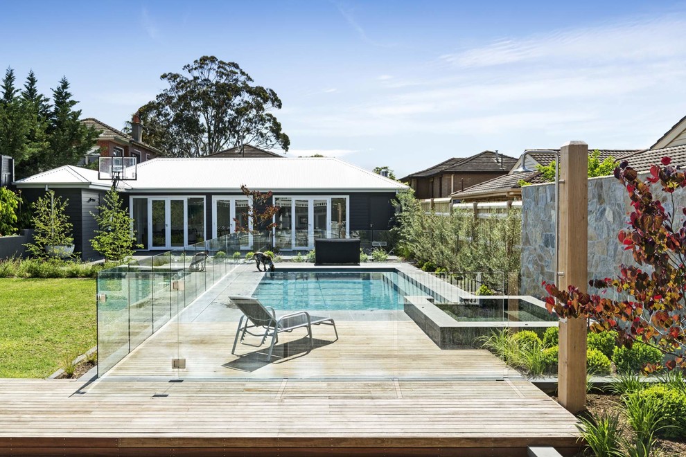 This is an example of a contemporary backyard rectangular pool in Melbourne with a hot tub and concrete pavers.