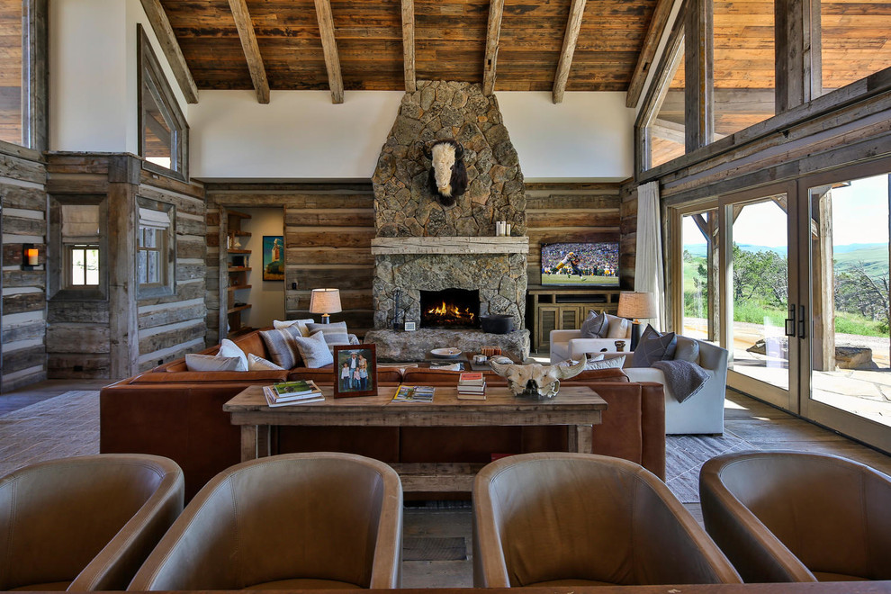 This is an example of a country open concept family room in Other with a standard fireplace and a freestanding tv.