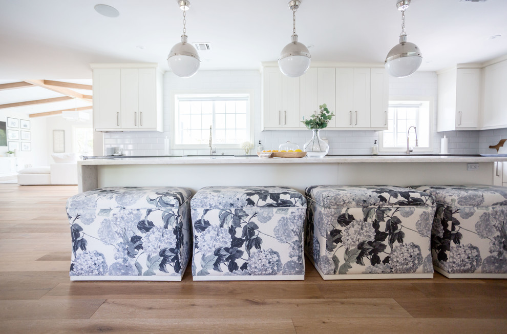 Example of a large transitional u-shaped light wood floor and brown floor eat-in kitchen design in Phoenix with a farmhouse sink, recessed-panel cabinets, white cabinets, quartz countertops, white backsplash, subway tile backsplash, stainless steel appliances, an island and white countertops