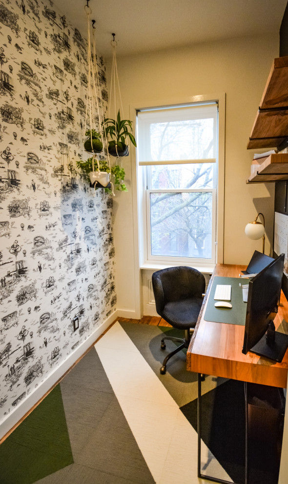 Exempel på ett litet industriellt arbetsrum, med svarta väggar, heltäckningsmatta, ett fristående skrivbord och flerfärgat golv