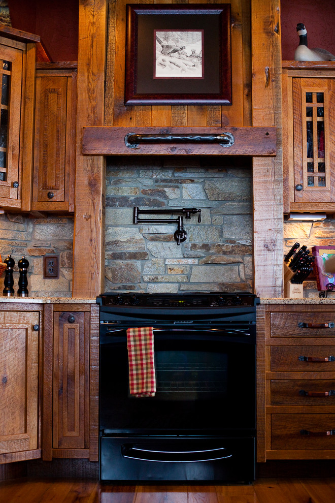 Example of a large mountain style u-shaped light wood floor eat-in kitchen design in Other with flat-panel cabinets, light wood cabinets, granite countertops, beige backsplash, stone tile backsplash, black appliances and no island