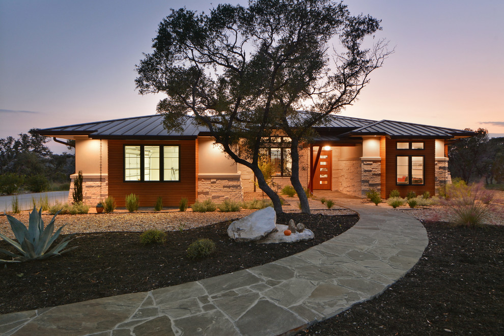Example of a large minimalist white one-story mixed siding house exterior design in Austin with a hip roof and a metal roof