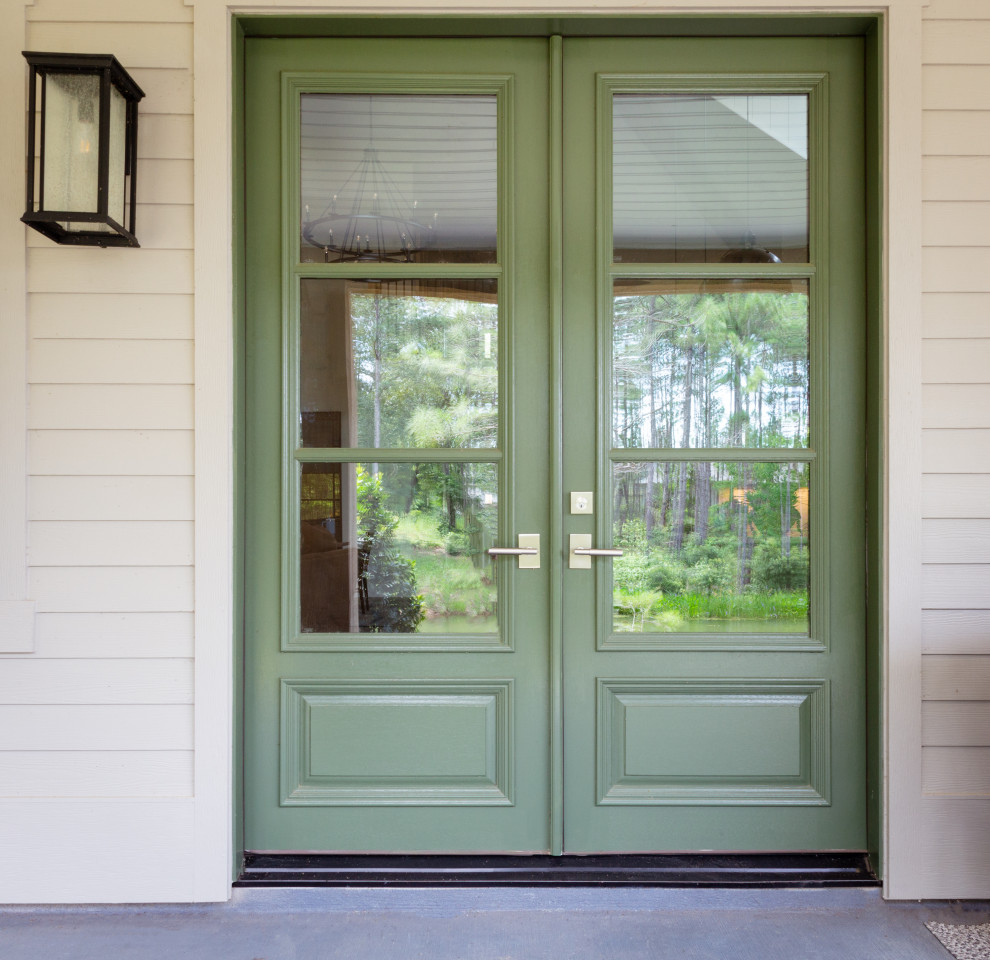 Esempio di un ingresso o corridoio american style con una porta a due ante e una porta verde