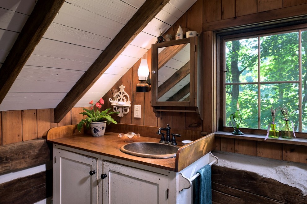 Photo of a country bathroom in Louisville with wood benchtops, a claw-foot tub and a two-piece toilet.