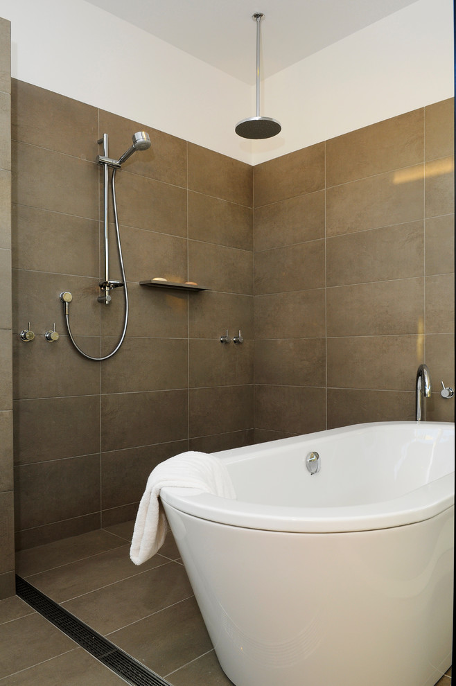 This is an example of a large contemporary master bathroom in Sydney with flat-panel cabinets, white cabinets, a freestanding tub, an open shower, a one-piece toilet, brown tile, porcelain tile, blue walls, travertine floors, a vessel sink, engineered quartz benchtops, brown floor, an open shower and brown benchtops.