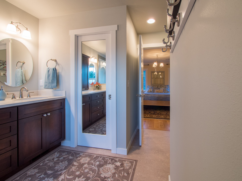 This is an example of a mid-sized country master bathroom in Seattle with shaker cabinets, dark wood cabinets, a double shower, a two-piece toilet, green tile, porcelain tile, blue walls, linoleum floors, an undermount sink, solid surface benchtops, beige floor, a hinged shower door, white benchtops, a shower seat, a double vanity and a built-in vanity.