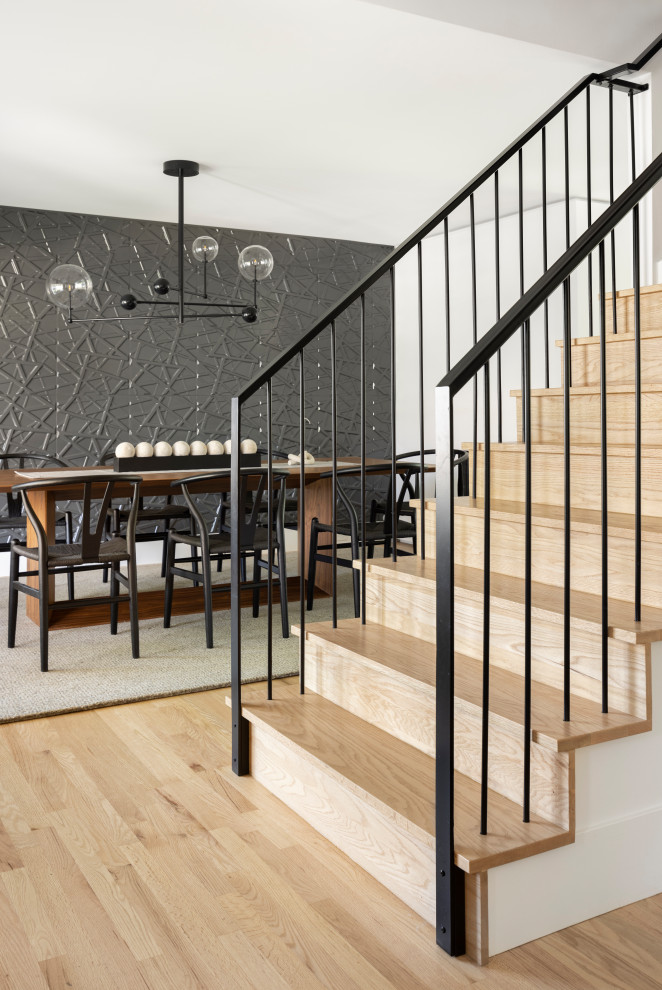 Diseño de escalera recta actual con escalones de madera, contrahuellas de madera y barandilla de metal