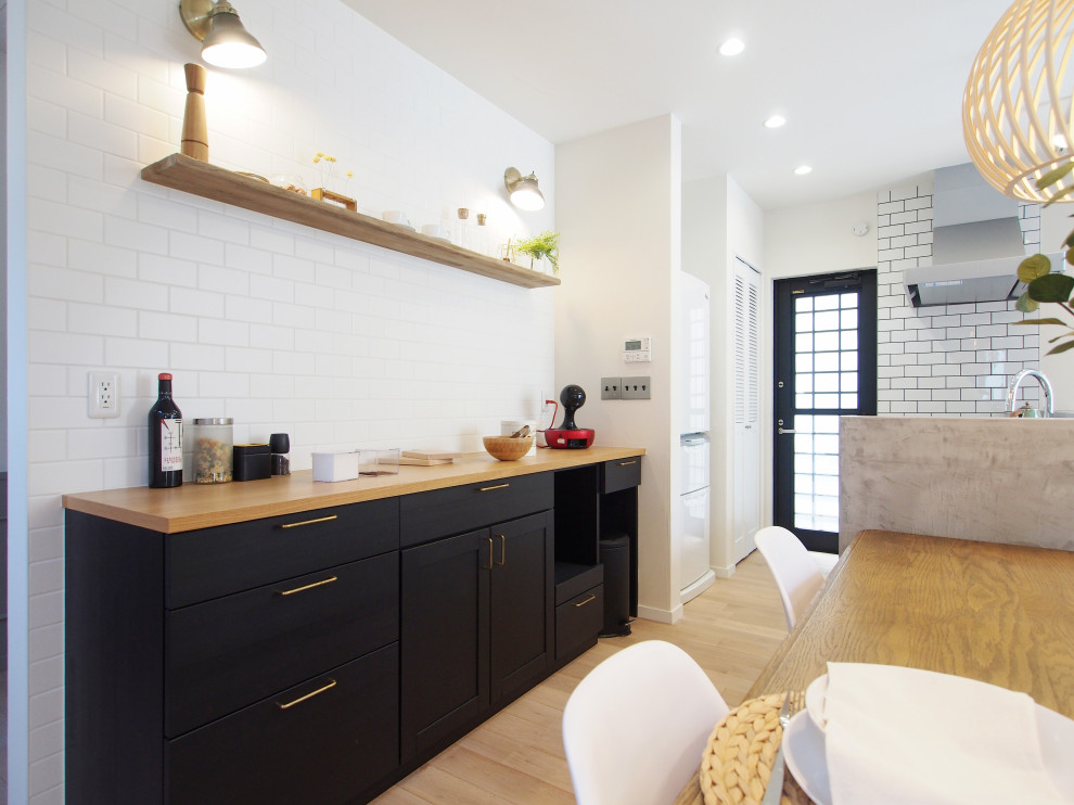 Foto di una cucina nordica con ante nere, top in legno, paraspruzzi bianco, paraspruzzi con piastrelle diamantate, parquet chiaro, pavimento beige e top beige