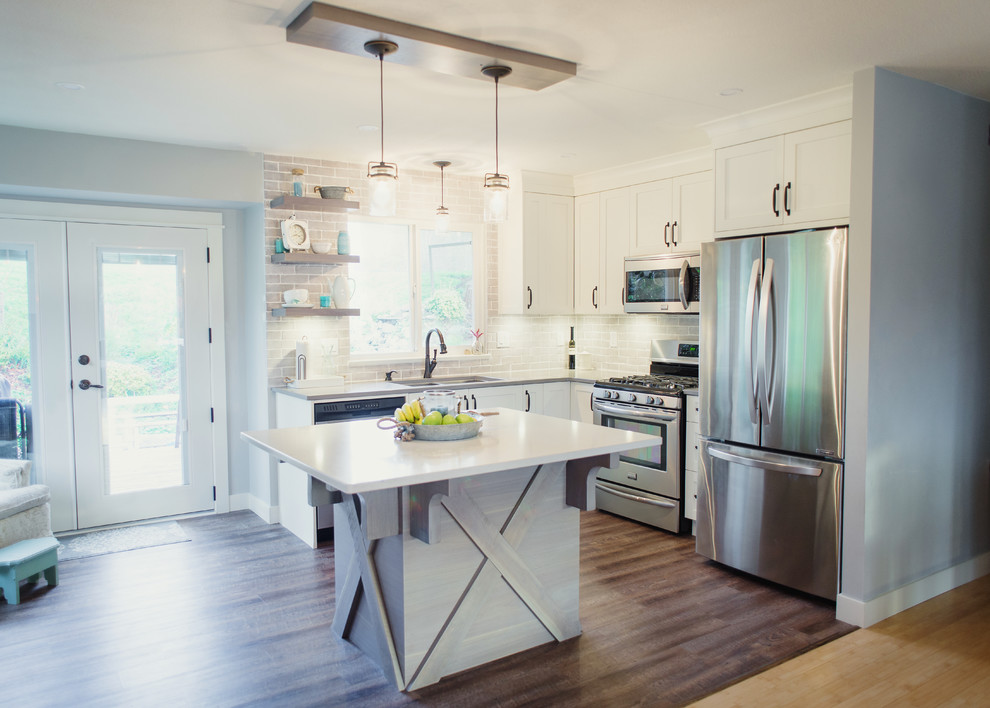 Example of a mid-sized transitional l-shaped eat-in kitchen design in Vancouver with an undermount sink, shaker cabinets, white cabinets, quartz countertops, gray backsplash, stainless steel appliances, an island, porcelain backsplash and white countertops