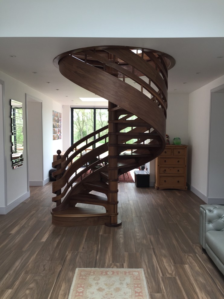 This is an example of a mid-sized contemporary wood spiral staircase in Other with wood risers and wood railing.