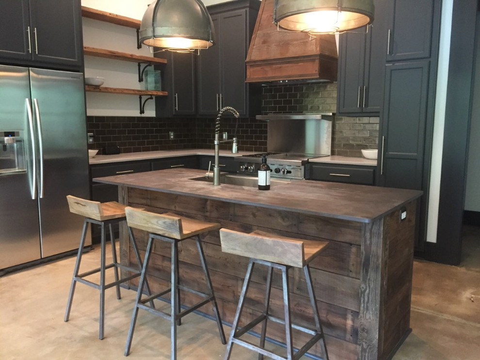 Inspiration for a mid-sized rustic l-shaped gray floor and concrete floor enclosed kitchen remodel with a farmhouse sink, shaker cabinets, blue cabinets, wood countertops, subway tile backsplash, stainless steel appliances, an island, brown countertops and metallic backsplash