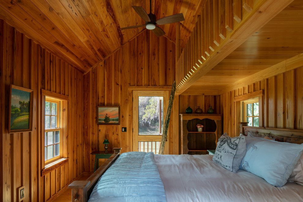 Exemple d'une chambre parentale nature en bois de taille moyenne avec parquet clair et un plafond voûté.