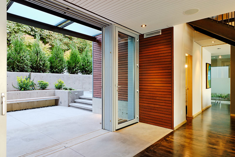 Inspiration for a mid-sized contemporary backyard patio in Seattle with concrete slab and a roof extension.