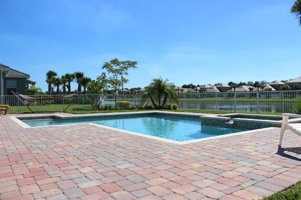 Example of a transitional backyard brick pool design in Miami