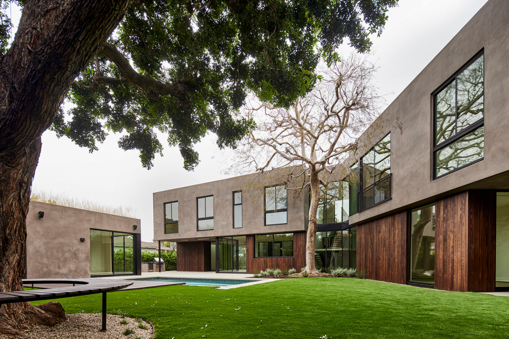 На фото: огромный, двухэтажный, деревянный, бежевый частный загородный дом в стиле модернизм с плоской крышей и зеленой крышей