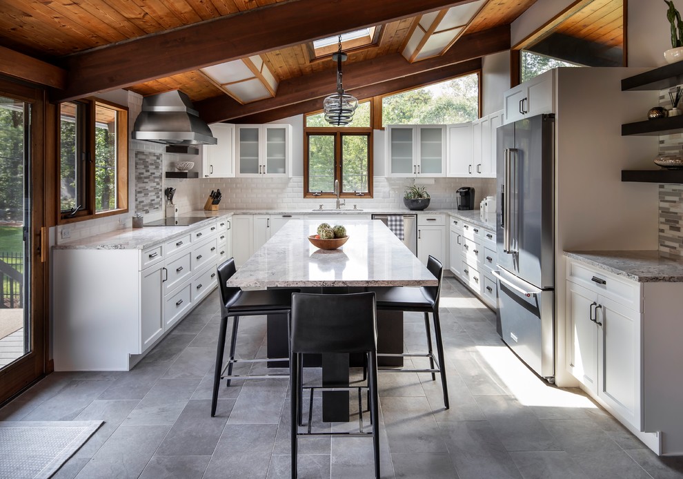Mid-sized midcentury u-shaped eat-in kitchen in Boston with an undermount sink, white cabinets, quartz benchtops, subway tile splashback, stainless steel appliances, porcelain floors, with island, grey floor, recessed-panel cabinets, white splashback and grey benchtop.