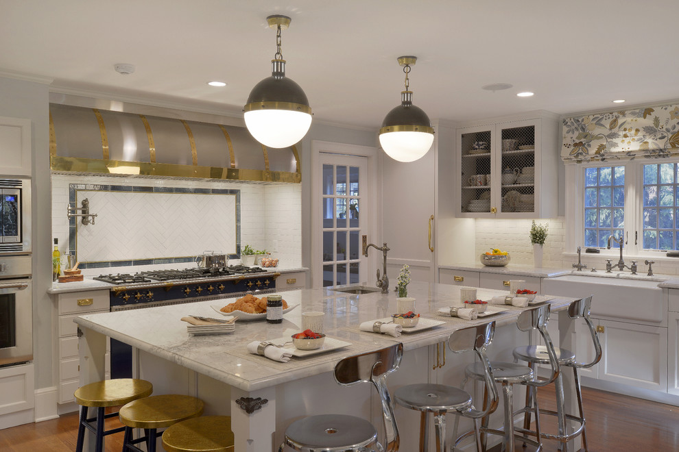 Photo of an expansive transitional l-shaped eat-in kitchen in New York with a farmhouse sink, recessed-panel cabinets, white cabinets, quartzite benchtops, white splashback, ceramic splashback, coloured appliances, dark hardwood floors and multiple islands.