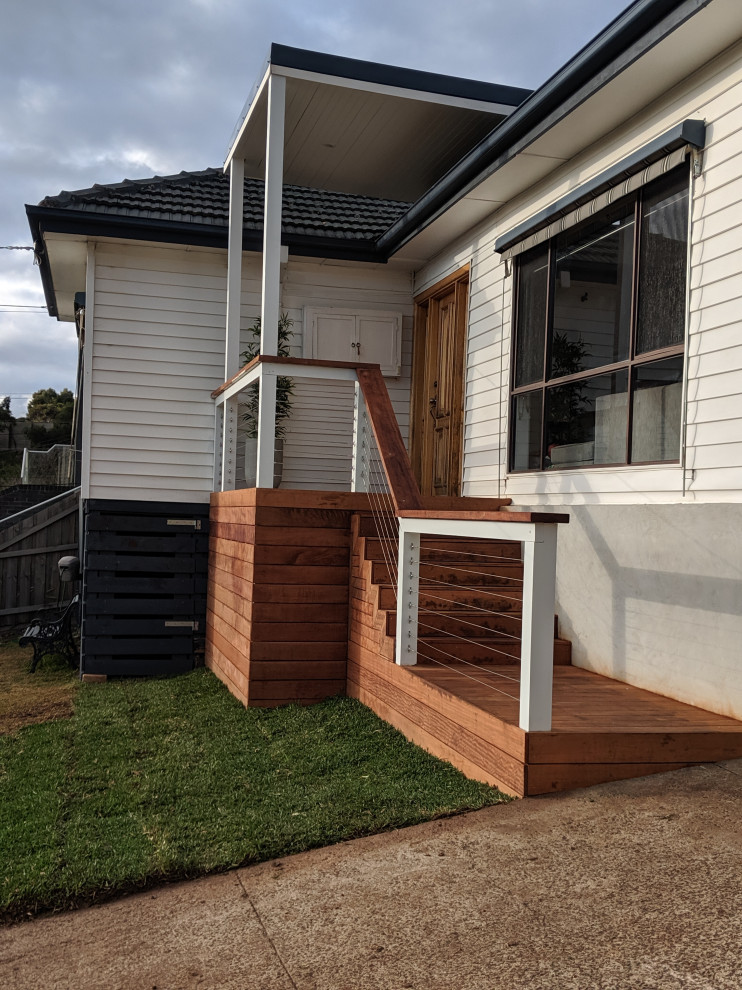 Design ideas for a mid-sized modern side yard and ground level deck in Melbourne with a pergola and wood railing.