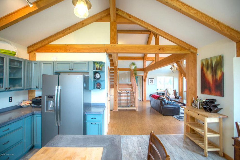 This is an example of a large country u-shaped eat-in kitchen in Other with a farmhouse sink, recessed-panel cabinets, turquoise cabinets, concrete benchtops, grey splashback, stone tile splashback, stainless steel appliances, ceramic floors, with island, grey floor, grey benchtop and wood.