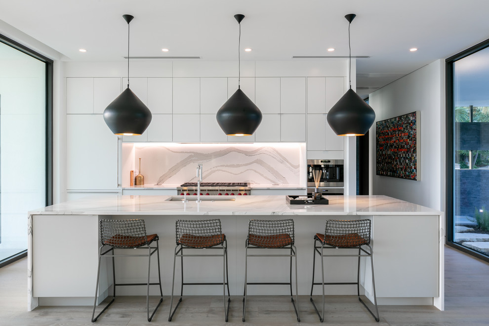 Design ideas for a large contemporary single-wall open plan kitchen in Other with an undermount sink, flat-panel cabinets, quartz benchtops, multi-coloured splashback, panelled appliances, medium hardwood floors, with island, brown floor, stone slab splashback and white benchtop.